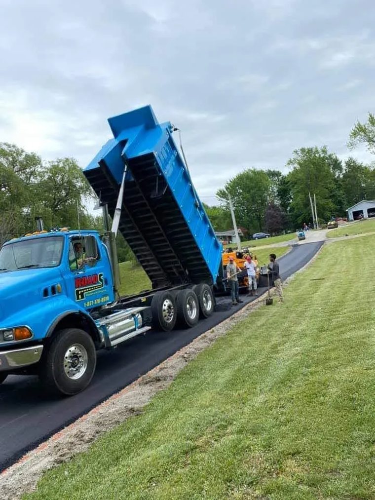Roads Paving truck delivering hot mix asphalt for a repair job
